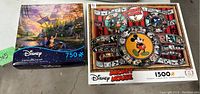 Two Disney puzzles boxes placed side by side, showing the Disney Imagineering 750-piece puzzle and the Mickey Mouse 1500-piece puzzle.