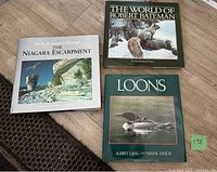 Three hardcover coffee table books arranged on floor: The Niagara Escarpment, The World of Robert Bateman, Loons.