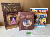 Three pop-up books side by side showing covers: Gods & Heroes, Harry Potter Hogwarts School, Celebrity Meltdowns