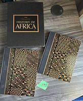 Two hardcover volumes with African tribal patterned covers resting outside the black slipcover titled 'The Horizon History of Africa'.