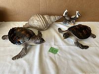 Lot showing all items including Bowring turtles, pelican candle holders, and artificial sea shell
