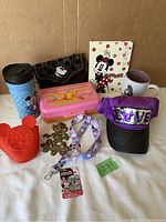 Full lot of Disney items including mugs, handbag, lanyard, hat, pot holder, address book, container, and brass hook