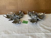 Two moose antler candle holders each with three glass candle cups on a white cloth background with cardboard behind