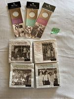 Four packets of napkins and three wine bottle tags in original wrappers laid flat on a white surface