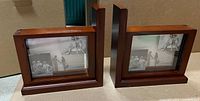 Front view of the two wooden photo bookends with glass photo frames containing black and white photos.