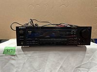 Front view of Pioneer VSX-451 stereo receiver showing model label and front panel buttons, switches, and display area with cabling behind it.