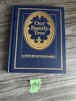 Cover of the family tree book showing dark blue hardcover with gold embossed title and border.
