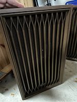 Front view of one Kenwood speaker showing vertical slat wooden grille and Kenwood logo