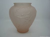 Front view of a pink satin glass vase with embossed poppy flower decorations, set against a white background.