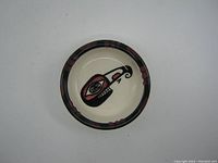 Top view of the pottery dish showing Mosquito design in center and rim pattern