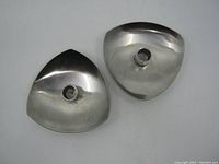 Top view of two triangular stainless steel candle sticks showing the polished metal surface and central candle sockets.