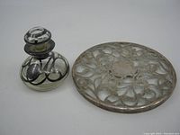 Perfume bottle and coaster side by side on a white background showing size and design