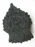 Top front view of hand carved wood fabric stamp showing detailed floral and vine design.