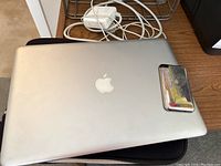 Closed MacBook Pro top view on cloth case with charger and iPod leaning on lid