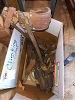 Box containing leather climbing belt and spurs, rope partially visible