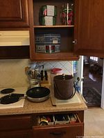 Kitchen cabinet with boxed glasses, pitcher, and kitchen utensils