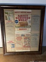 Full view of oak framed collection of Nabisco Shredded Wheat antique papers including original product labels and advertisements.