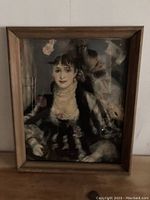 Framed print showing full artwork of woman in dark costume with lace and pearls, wooden frame visible