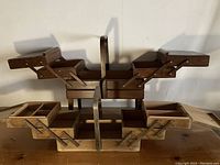 View of both sewing boxes open showing multi-tiered accordion compartments and central handles