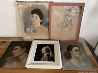 All four original portrait paintings arranged showing framed and unframed pieces.