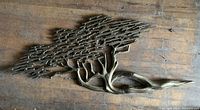 Full view of cast brass tree wall sculpture on wooden floor