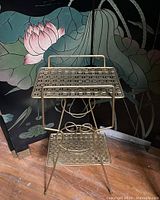 Overview image of the vintage mid century metal side table showing two perforated shelves and overall structure.