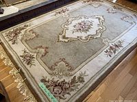 View of entire rug showing overall floral design and rectangular shape with fringed edges.