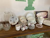 Collection of Bunnykins bowl, Mother's Day plate, cups, demi-tasse, bowls, glassware including pitcher and clear bowls arranged on wooden surface
