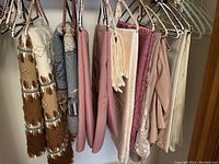 Handmade wool blanket and assorted linens hanging on hangers in closet