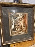 Abstract artwork in a gold frame showing the full piece and matte border.