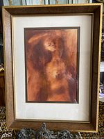 Full view of framed artwork showing the nude lady figure in warm hues and wooden frame.