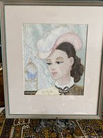 Framed painting showing the full artwork of a young lady with a bird cage
