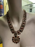 Front view on mannequin showing overall bib-style necklace