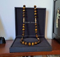 Full-length view of the 36" necklace draped in the open Georg Jensen box