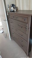 Full front angle view of the Ikea dresser showing 5 drawers and decor items on top
