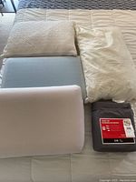 Overview of four pillows and twin sheet set on bed