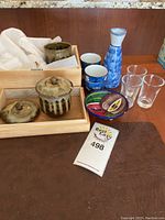 Overview of the tea set, sake set, shot glasses and decorative plate on wooden surface