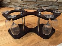 Side view of the 6 mini wine glass set with decorative wood holder showing 4 glasses hanging inverted plus two more on the back, and metal rods connecting two wood panels