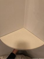 Top view showing the triangular shape of the ivory corner shelf, designed to fit into a corner space.