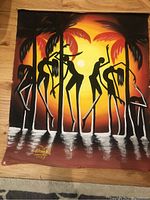 Full view of a large Egyptian style canvas painting in warm sunset colors featuring black silhouetted figures and palm trees with 'Ahmed 2002' signature.