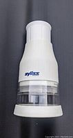Front view of white Zyliss food chopper showing the pull-cord top and transparent container.
