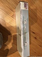 Box contains Target Home Classic glass shelf with polished chrome finish and mounting hardware, showing brand and size details on the packaging.