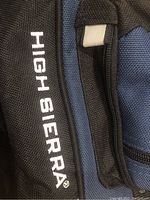 Close-up of High Sierra branded name on black fabric section of the duffel bag.