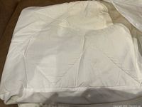 Photo of the white king size mattress protector, showing quilted stitching and clean condition.