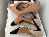 Two pairs of women's suede high heel shoes displayed showing color, style, and condition. Beige pair on top, multicolor pair with pointed toes and cutout design below.