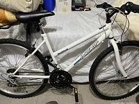 Full side view of women's bicycle showing white frame with NEXT branding, black seat and tires.