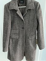 Front view of women's Jacob coat, showing brown textured fabric, collar, front buttons, and flap pockets.