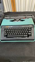Top view of teal and black Brother Correct O'Matic 21 Cassette Typewriter showing keys and carriage.