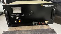 Front view of the Coherent Associates modulation system with analog voltage meter, control switches, and connection ports visible.