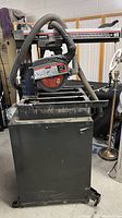 Front view of Sears Craftsman 10 inch radial saw on metal stand showing dust hose and general condition